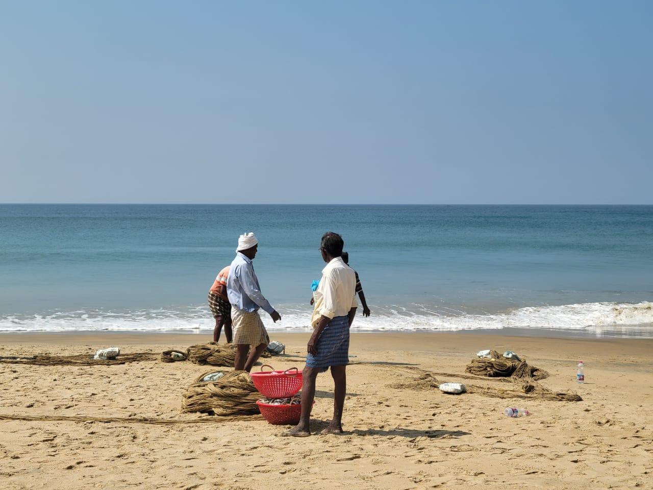 Fishermen mending nets on the beach
